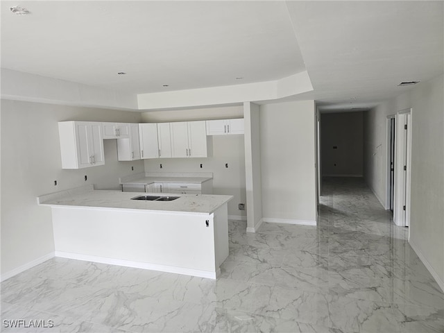 kitchen featuring white cabinetry and a center island with sink