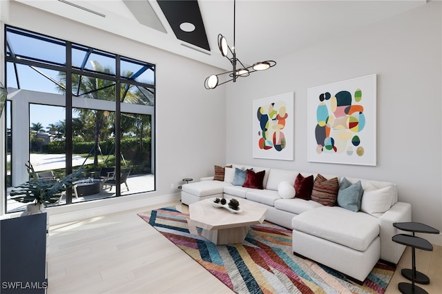 living room featuring a towering ceiling, wood-type flooring, and a wealth of natural light