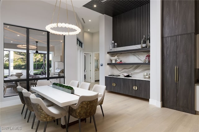 dining room with a high ceiling and light hardwood / wood-style floors