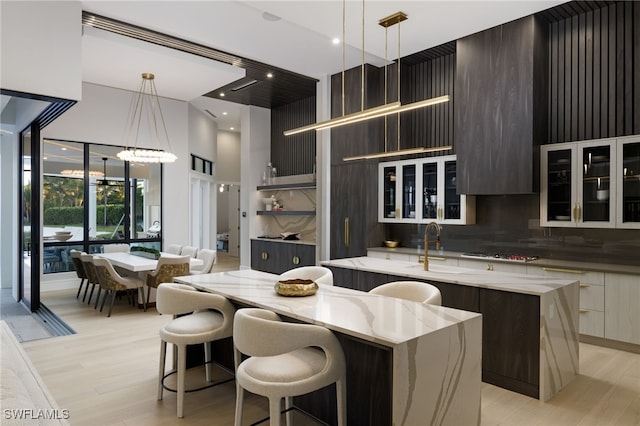 kitchen featuring backsplash, light hardwood / wood-style flooring, pendant lighting, and a kitchen island