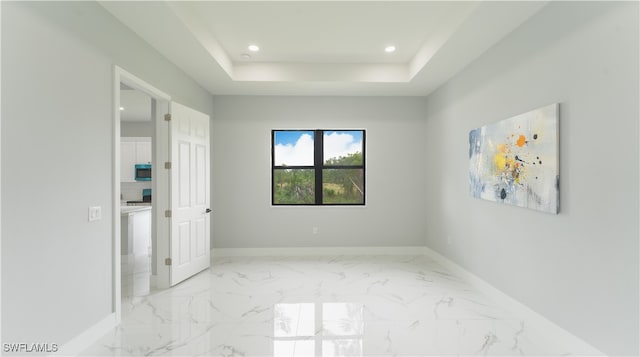 unfurnished room with a tray ceiling