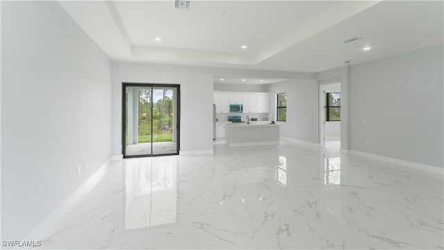 unfurnished living room featuring a tray ceiling