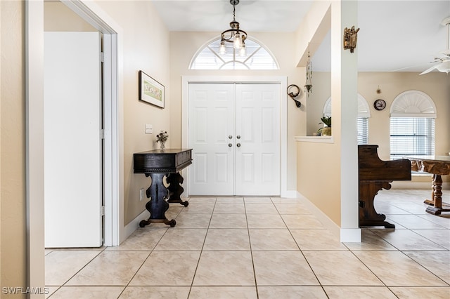 entryway with a healthy amount of sunlight, light tile patterned flooring, and ceiling fan