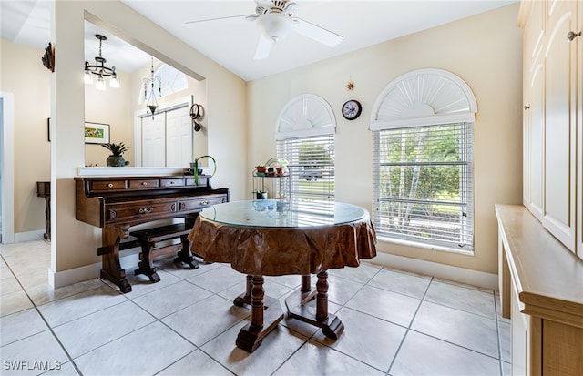 misc room featuring light tile patterned flooring and ceiling fan with notable chandelier