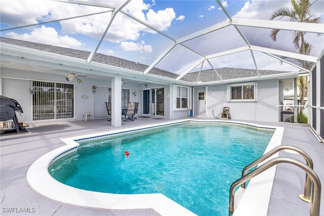 view of swimming pool featuring ceiling fan, a patio area, and a lanai