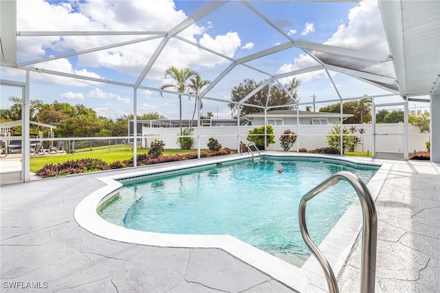 view of pool with a patio area and glass enclosure