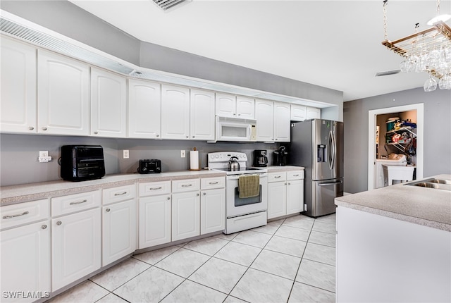 kitchen featuring white cabinetry, light tile patterned flooring, and white appliances