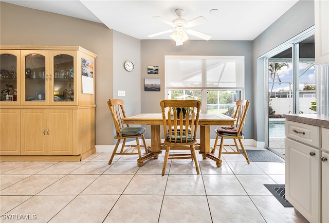 dining room featuring ceiling fan, lofted ceiling, and light tile patterned floors