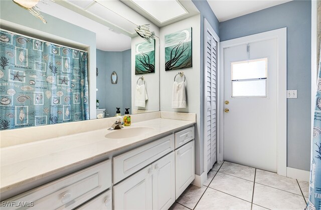 bathroom with vanity, toilet, and tile patterned floors