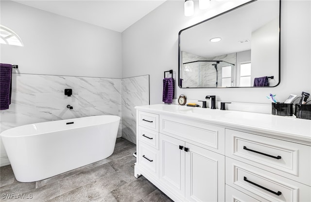 bathroom featuring tile walls, vanity, shower with separate bathtub, and a healthy amount of sunlight