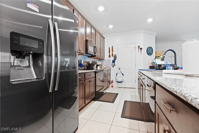 kitchen featuring crown molding, appliances with stainless steel finishes, light tile patterned floors, and light stone counters