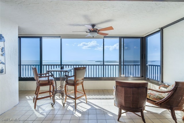 15021 Punta Rassa Rd Unit 902, Fort Myers, FL 33908 - sunroom with tile patterned floors, a water view, a textured ceiling, and a textured wall