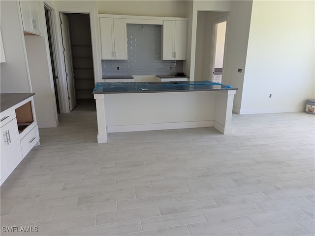 kitchen featuring decorative backsplash and white cabinets