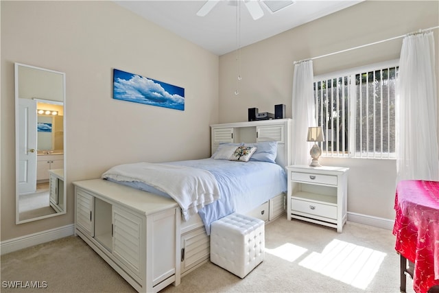 bedroom featuring ceiling fan, ensuite bathroom, and light colored carpet