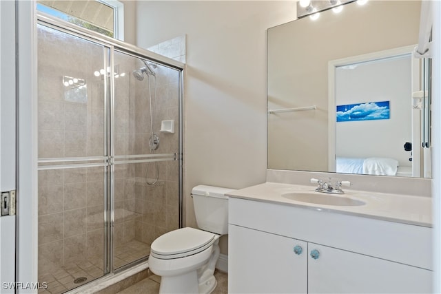 bathroom featuring toilet, vanity, and a shower with door