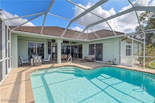 view of pool with ceiling fan, a lanai, and a patio area