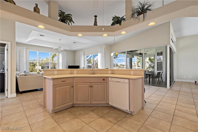 kitchen with ceiling fan, light brown cabinetry, dishwasher, and an island with sink