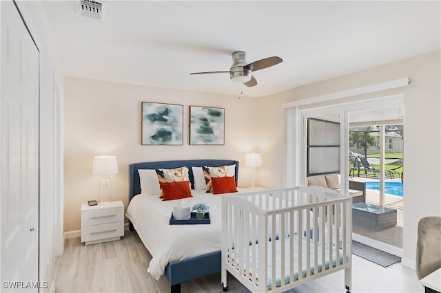 bedroom featuring access to exterior, baseboards, wood finished floors, and a ceiling fan