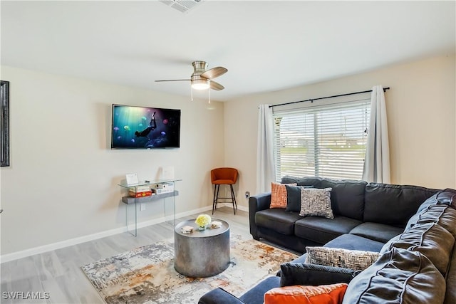 living room with wood finished floors, a ceiling fan, and baseboards