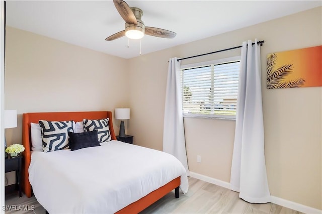 bedroom featuring baseboards, light wood-style flooring, and a ceiling fan