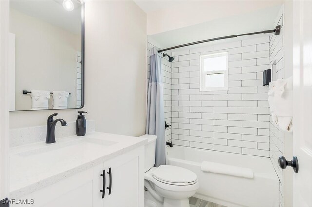 full bath featuring vanity, shower / tub combo with curtain, and toilet