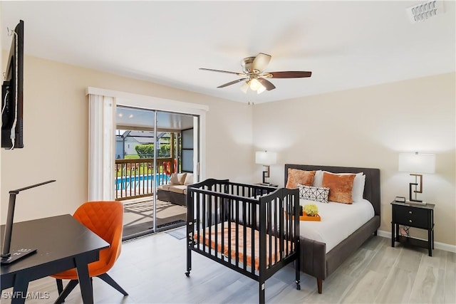 bedroom featuring light wood finished floors, access to outside, baseboards, an office area, and a ceiling fan