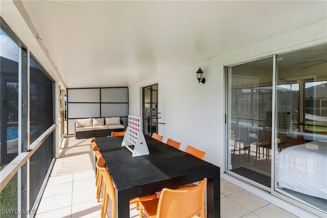 sunroom with tile patterned flooring and outdoor dining area