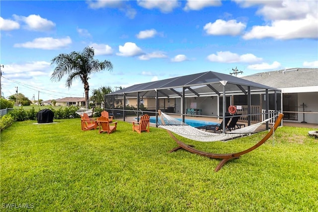 back of property featuring an outdoor pool, a yard, glass enclosure, and a patio area