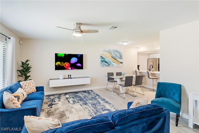 living room featuring ceiling fan, wood finished floors, and baseboards