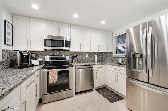 190 Pebble Beach Blvd Unit 103, Naples, FL 34113 - kitchen with appliances with stainless steel finishes, white cabinetry, light tile patterned flooring, backsplash, and recessed lighting
