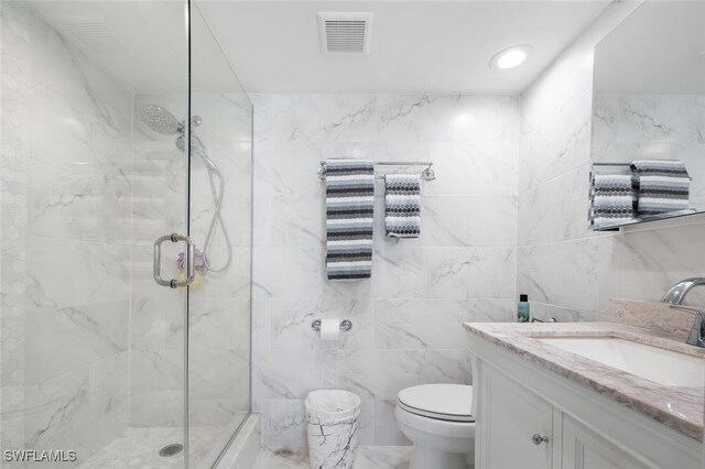 190 Pebble Beach Blvd Unit 103, Naples, FL 34113 - full bathroom featuring a shower stall, tile walls, vanity, and toilet