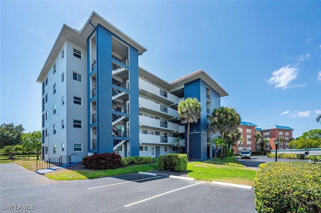 190 Pebble Beach Blvd Unit 103, Naples, FL 34113 - view of apartment building / complex featuring uncovered parking