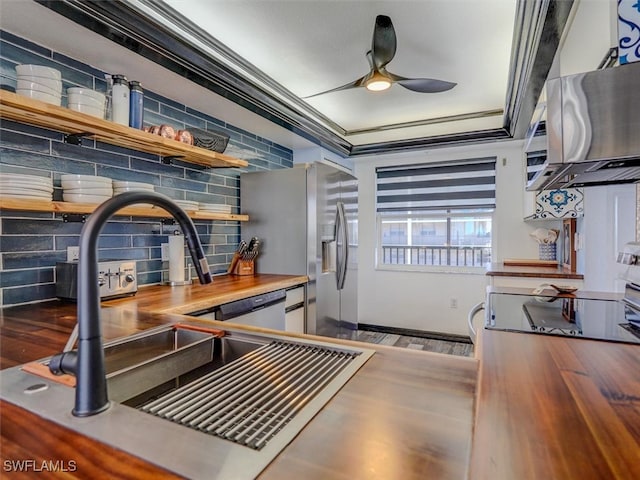 kitchen featuring tasteful backsplash, crown molding, dark hardwood / wood-style floors, wood counters, and ceiling fan