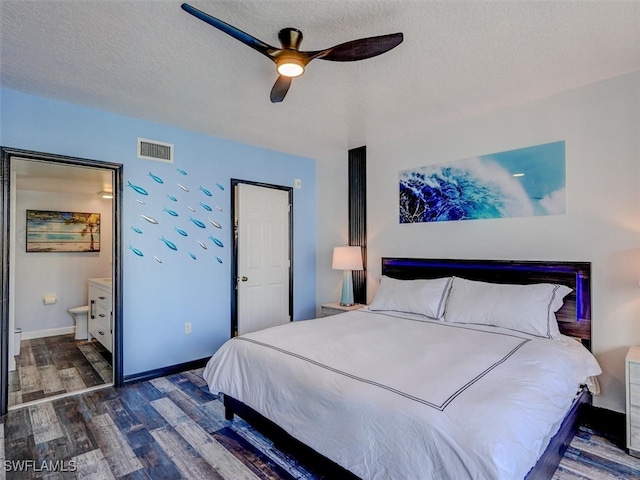 bedroom with a textured ceiling, ensuite bath, ceiling fan, and dark hardwood / wood-style floors