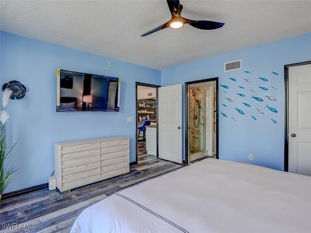 bedroom with dark wood-type flooring, ceiling fan, and a textured ceiling