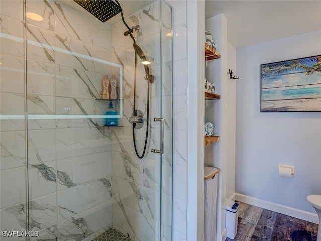 bathroom with toilet, hardwood / wood-style flooring, and a tile shower