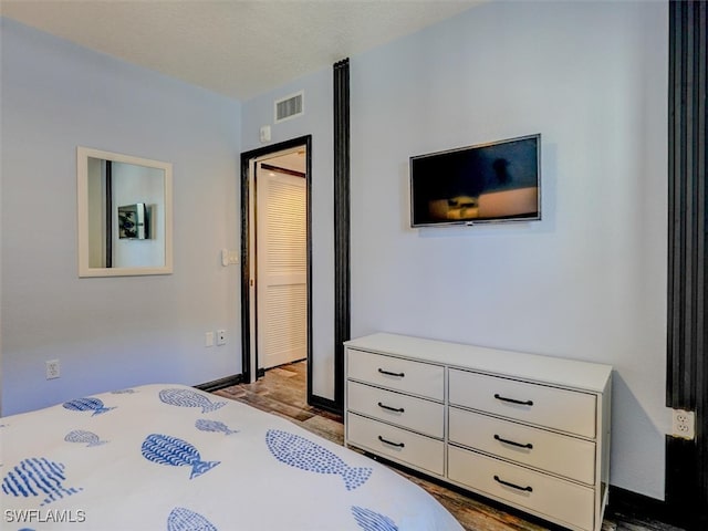 bedroom with a textured ceiling and light hardwood / wood-style flooring