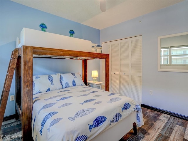 bedroom featuring ceiling fan, dark hardwood / wood-style floors, and a closet