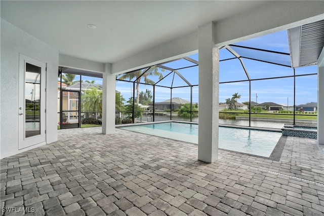 view of swimming pool featuring a patio, a lanai, and a water view