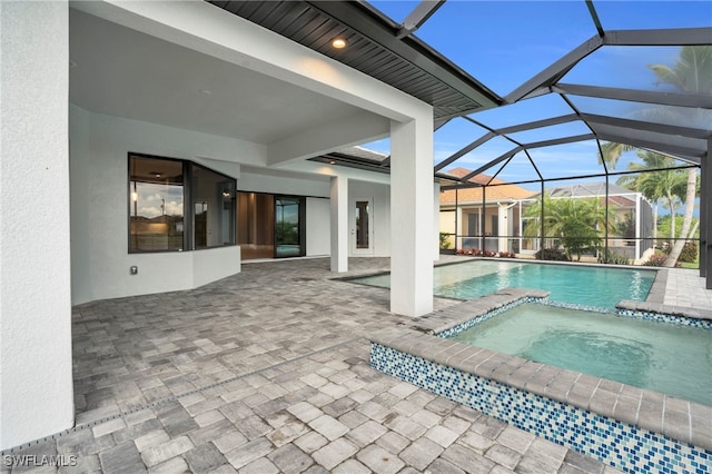 view of swimming pool with a patio, an in ground hot tub, and glass enclosure