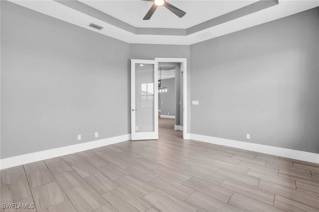 unfurnished room with a raised ceiling and ceiling fan