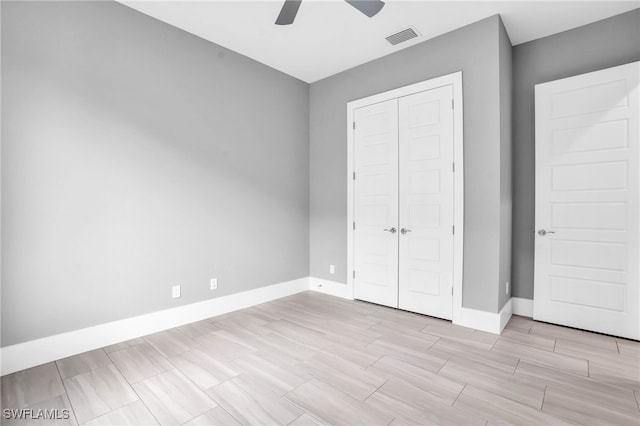 unfurnished bedroom with a closet, light wood-type flooring, and ceiling fan