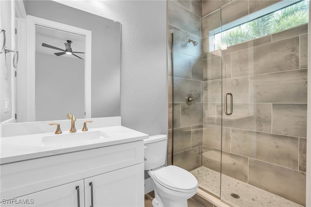 bathroom featuring toilet, wood-type flooring, vanity, an enclosed shower, and ceiling fan