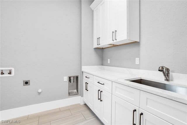 laundry area featuring sink, gas dryer hookup, electric dryer hookup, washer hookup, and cabinets