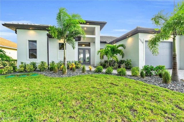 contemporary home with french doors, a front lawn, and a garage