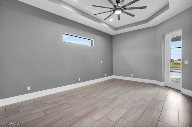 spare room featuring ceiling fan and a raised ceiling