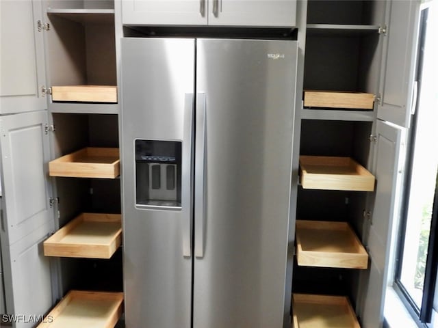 kitchen featuring white cabinets and stainless steel refrigerator with ice dispenser