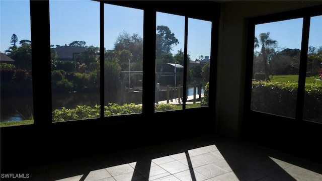 sunroom / solarium featuring a water view and a wealth of natural light