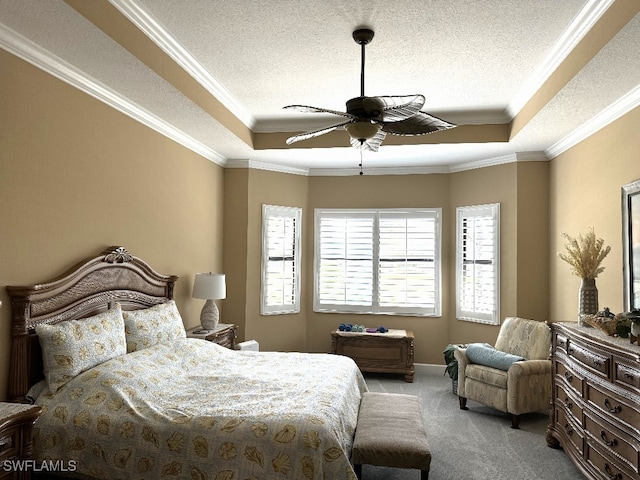 carpeted bedroom with a raised ceiling, ceiling fan, and ornamental molding