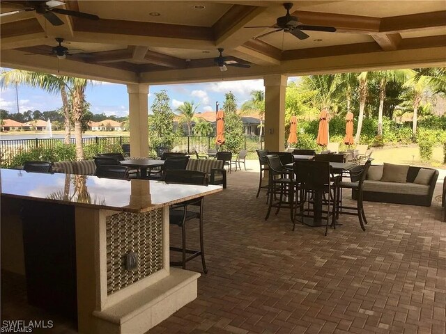 view of patio / terrace with exterior bar and ceiling fan